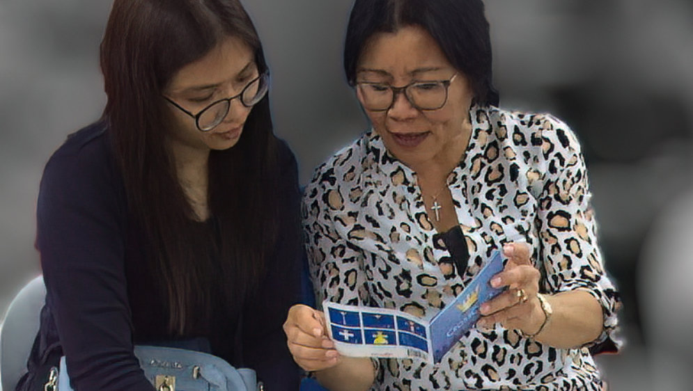 Two women looking at the CrossCheck booklet